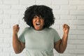 Angry african american woman screaming on brick background. Bad aggressive emotions and premenstrual syndrome or pms Royalty Free Stock Photo