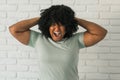 Angry african american woman screaming on brick background. Bad aggressive emotions and premenstrual syndrome or pms Royalty Free Stock Photo