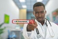 Angry african black male doctor pointing finger at you with stethoscope around his neck. Life insurance search