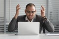 Angry african business man using laptop mad about computer problem Royalty Free Stock Photo