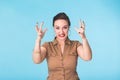 Angry aggressive woman with ferocious expression on blue background Royalty Free Stock Photo