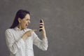 Angry aggressive woman nervously screaming looking with hatred at mobile phone screen. Royalty Free Stock Photo