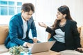 Angry asian businesswoman arguing with businessman about work failure at workplace. Royalty Free Stock Photo