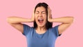 Angry asian woman covering her ears with hands and screaming Royalty Free Stock Photo