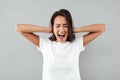 Angry asian woman covers her ears with hands and shouting Royalty Free Stock Photo