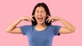 Angry asian woman plugging her ears with fingers and screaming Royalty Free Stock Photo