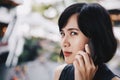 A angry asian woman talking her mobile phone in the mall. Royalty Free Stock Photo