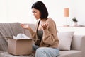 Angry asian woman unpacking wrong box, delivery mistake