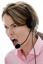 Angry Attractive Young Business Woman Using a Telephone Headset Royalty Free Stock Photo