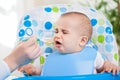 Angry baby doesn't like fruit mash Royalty Free Stock Photo