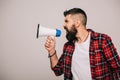 Angry bearded man in checkered shirt screaming into megaphone, isolated