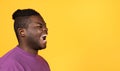 Angry black man shouting towards free space over yellow background Royalty Free Stock Photo
