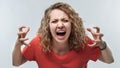 Angry blonde woman screaming and raising hands in anger. Negative emotion, facial expression concept