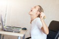 Angry blonde woman working on laptop at home and screaming She`s upset. Freelance, work at home concept Royalty Free Stock Photo