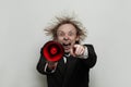 Angry boss businessman with red loudspeaker shouting and pointing finger on white background, studio portrait