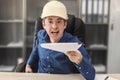 The angry boss in a helmet at his desk is holding out the cocktails. Blurred background. Builder, engineer, architect, foreman Royalty Free Stock Photo