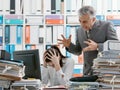 Angry boss yelling at his young employee Royalty Free Stock Photo