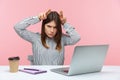 Angry bossy woman office worker holding fingers above head showing bull horns sitting at workplace, threatening looking angrily at