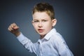 Angry boy isolated on gray background. He raised his fists to strike. Closeup Royalty Free Stock Photo