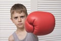 Angry boy in red boxing glove. Hit