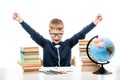 angry boy at table with books and globe against white