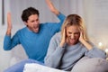 Angry Boyfriend Shouting At Girlfriend Sitting On Couch Indoor