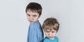 Angry boys frowning, looking forward. Light background. Closeup