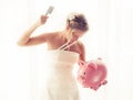 Angry bride with knife in hand about to smash piggy bank Royalty Free Stock Photo