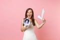 Angry bride woman in wedding dress screaming in megaphone holding check mark on pink pastel background. Wedding