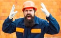 Angry builder. Incident at a construction site. Safety rules for builders. Bearded man in helmet on the construction of Royalty Free Stock Photo