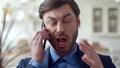 Angry business man talking emotionally on mobile phone. Annoyed man yelling. Royalty Free Stock Photo