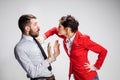 The angry business man and woman conflicting on a gray background