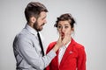 The angry business man and woman conflicting on a gray background