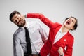 The angry business man and woman conflicting on a gray background