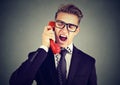 Angry young business man yelling on the phone Royalty Free Stock Photo