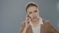 Angry business woman calling mobile phone in studio. Angry businesswoman Royalty Free Stock Photo