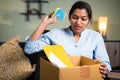 Angry business woman employee throwing sticky notes inside the box due to loss of job, fired, laid off or terminated