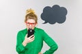 Angry business woman looking at phone, thinking bubble Royalty Free Stock Photo