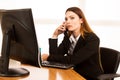 Angry business woman talks on smert phone in office at her desk Royalty Free Stock Photo