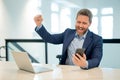 Angry businessman chatting phone online in office. Sad stressed business man in suit using phone. Stressed office worker Royalty Free Stock Photo