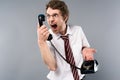 Angry businessman in glasses screaming in vintage phone. Royalty Free Stock Photo