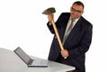 Angry businessman hitting laptop with sledgehammer