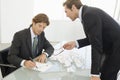 Angry Businessman With Male Colleague Writing On Paper Royalty Free Stock Photo