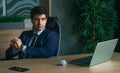 Angry businessman working with laptop in modern office. Crumples and throws sheets of paper.Problems in business of
