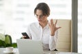 Angry businesswoman annoyed with stuck not working phone in offi