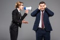 angry businesswoman with bullhorn screaming at businessman