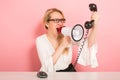 Angry businesswoman with phone and loudspeaker