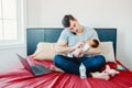 Angry busy Caucasian father with newborn Asian Chinese baby working from home.