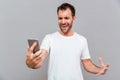 Angry casual man holding smartphone Royalty Free Stock Photo
