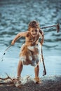 Angry caveman, manly boy with primitive weapon hunting outdoors. Ancient prehistoric warrior. Heroic movie look Royalty Free Stock Photo